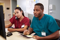 Photo of two nurses in a nurses station.